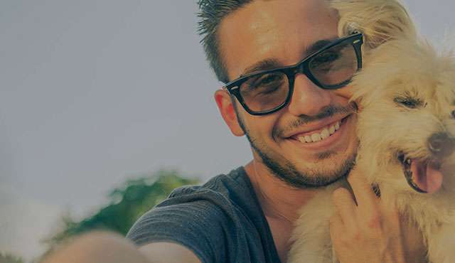 Man hugging a little white dog